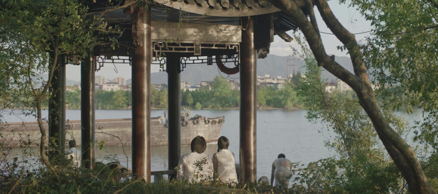image du film Séjour dans les monts fuchun où deux personnages sont assis devant une étendue d'eau